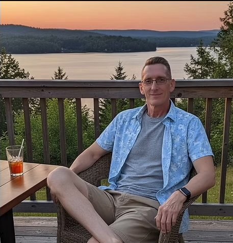 Chip Bridgmon relaxing on a deck overlooking a lake at sunset